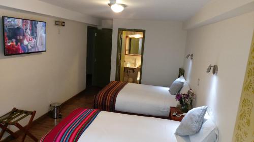 a room with two beds in a hotel room at Hotel Pucara Machupicchu in Machu Picchu