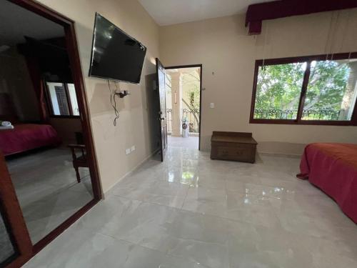 a living room with a tv on the wall at Hotel Nojoch che in Cobá