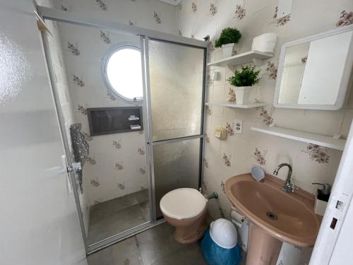 ein Bad mit einer Dusche, einem WC und einem Waschbecken in der Unterkunft Itapema-Meia Praia- 3 quartos - Frente Mar! in Itapema