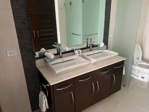 a bathroom with two sinks and a large mirror at Brand New and Amazing Penthouse! in Playa del Carmen