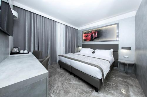 a hotel room with a bed and a desk at Best Western Premier Milano Palace Hotel in Modena