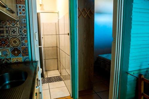 a bathroom with a shower and a glass door at Residencial Solar Três in Imbé