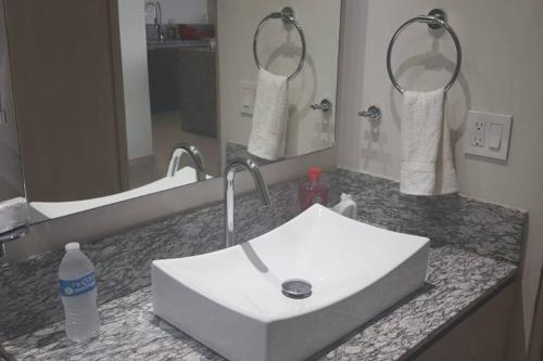 a bathroom with a white sink and a mirror at Precioso departamento en Acapulco Diamante in Acapulco
