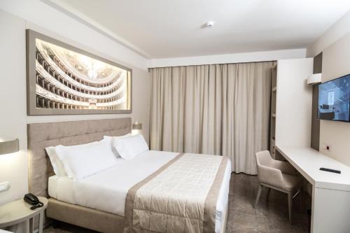 a hotel room with a bed and a television at Best Western Premier Milano Palace Hotel in Modena