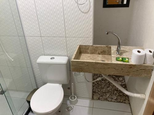 a bathroom with a toilet and a sink at Vila Itacimirim in Itacimirim