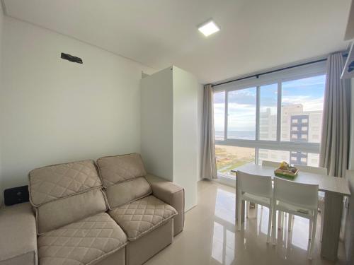 sala de estar con sofá y mesa en Apartamento com vista para o mar, en Capão da Canoa