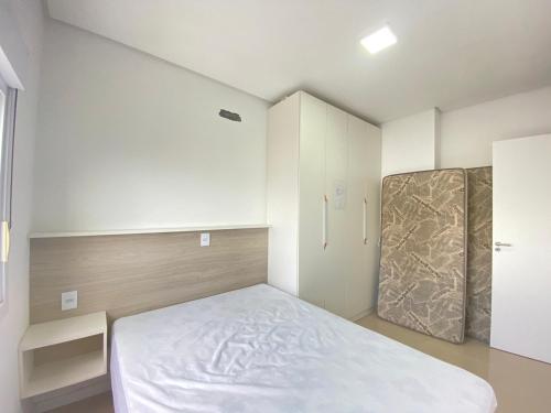 Dormitorio pequeño con cama y armario en Apartamento com vista para o mar en Capão da Canoa