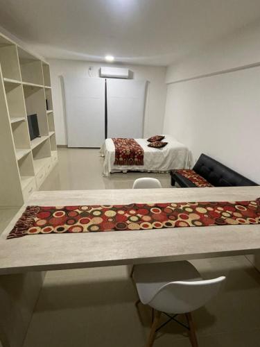 Habitación con cama y mesa con alfombra. en Departamento Pueyrredón en Salta