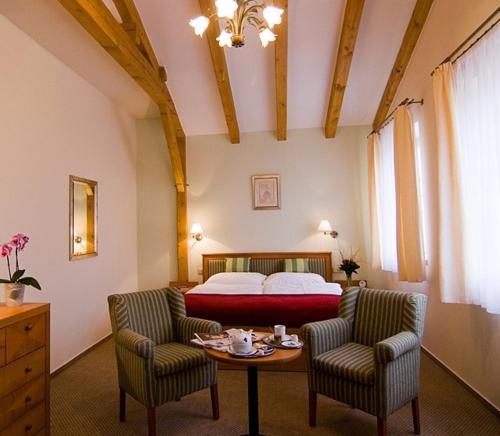 a bedroom with a bed and a table and chairs at Castle Residence Praha in Prague