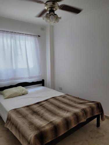 Schlafzimmer mit einem Bett und einem Deckenventilator in der Unterkunft Apartamento Alem in Gualeguaychú