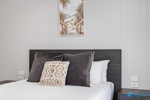 1 cama con 2 almohadas y una foto en la pared en Hive Hotel, Moruya, en Moruya