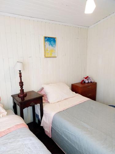 安庫德的住宿－Cabañas Don Peto，一间卧室配有两张床和一张带台灯的桌子