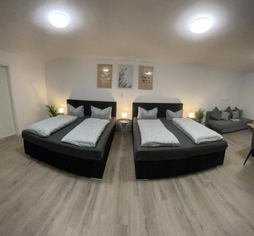two beds in a room with two chairs and a couch at Giulias Budget Haus in Reutte