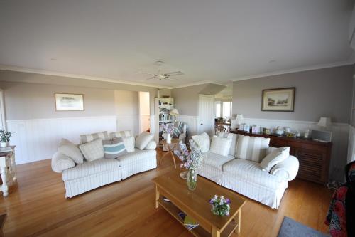 a living room with two white couches and a table at Grey Goose @ Smiths in Smiths Beach