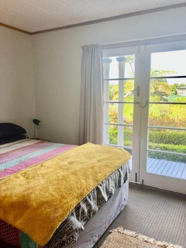 a bedroom with a bed and a sliding glass door at Tripinn Modern Motels & Affordable Accommodation in Westport