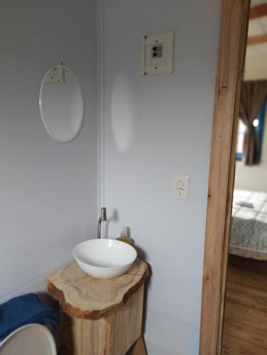 a bathroom with a white sink on a wooden table at Bangalô dos Araçás - sítio Vô Haack in Gramado