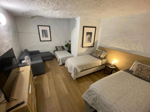 uma sala de estar com duas camas e um sofá em 894 Holly Court em Coober Pedy