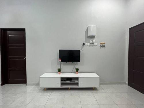 a white living room with a tv on a white wall at D'Sara Homestay Fully Furnished 3 bedrooms All Aircond 2 miles centre in Kemaman