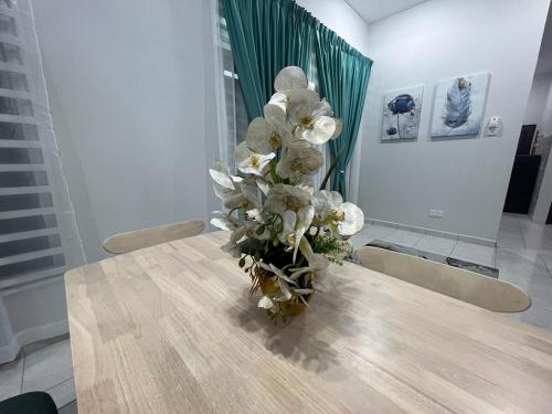 a vase of white flowers sitting on a table at D'Sara Homestay Fully Furnished 3 bedrooms All Aircond 2 miles centre in Kemaman
