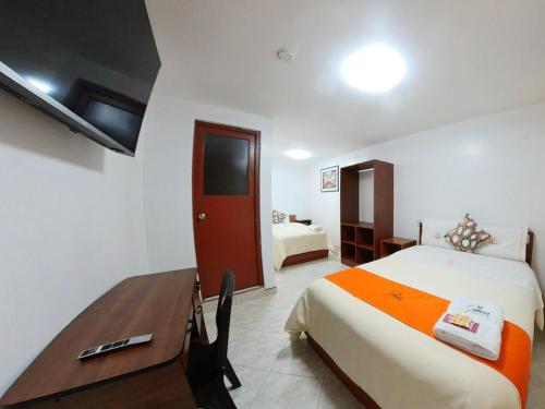Sumaq Dreams Ayacucho في اياكوتشو: غرفة فندق بسرير ومكتب وغرفة نوم