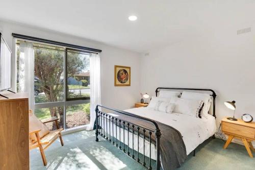 a bedroom with a bed and a large window at Beachside Serenity - a quiet beachside hideaway in Mount Martha