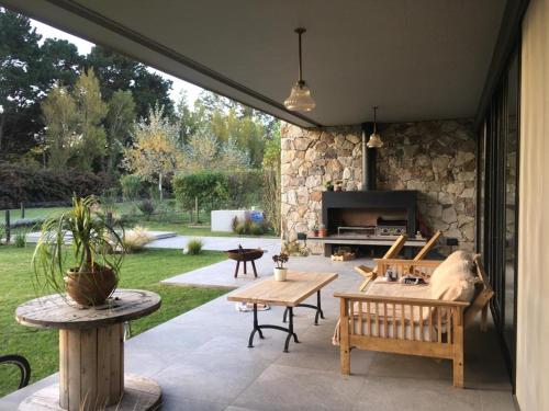 a patio with a table and chairs and a fireplace at Casa grande barrio Rumenco in Mar del Plata