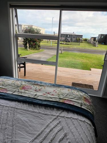 a bedroom with a view of a deck with a window at Opotiki Waiotahi Beach Retreat in Opotiki