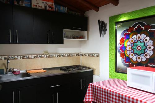 a kitchen with black cabinets and a colorful wall at EL RETORNO in Marinilla