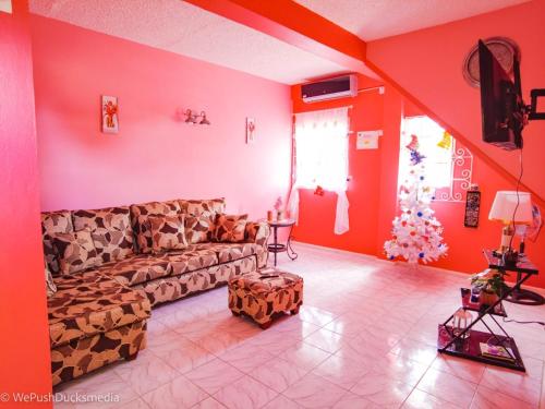 a living room with red walls and a couch at Coco Rose Apartments in Soufrière