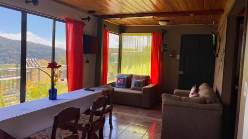 a living room with a table and chairs and a large window at Lidia's Mountain View Vacation Homes in Monteverde Costa Rica
