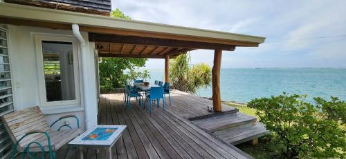a house with a deck with a table and chairs at Villa Vaihau in Papetoai