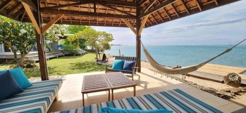 a porch with a hammock and a view of the ocean at Villa Vaihau in Papetoai