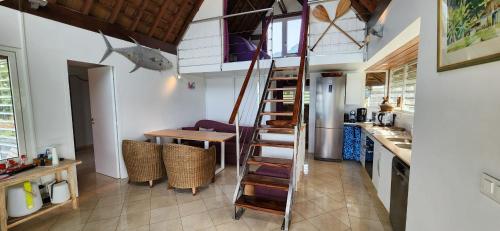 a kitchen with a spiral staircase in a house at Villa Vaihau in Papetoai