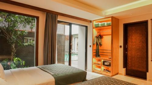 1 dormitorio con 1 cama y puerta corredera de cristal en Annora Villas Seminyak en Seminyak