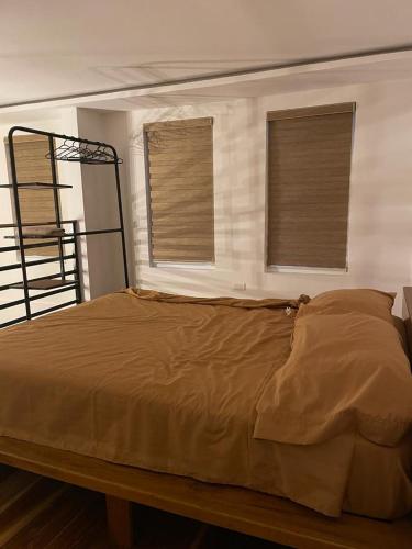 埃斯梅拉達斯的住宿－Departamento en Esmeraldas，一张大床,位于带两个窗户的房间