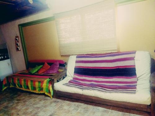 Una habitación con una cama con una manta de colores. en La CUEVA DEL OSO en San Rafael