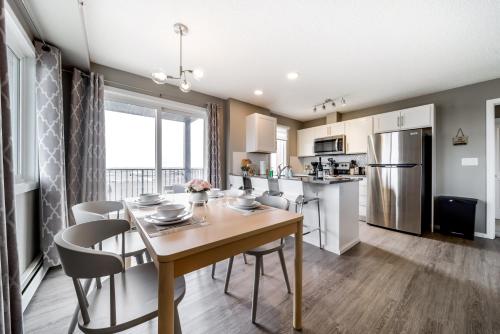 a kitchen and dining room with a table and chairs at Peaceful Oasis Condo, AC, Top Floor, Secure UG Parking, Balcony, King Bed! in Edmonton