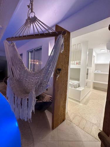 um quarto com uma rede de descanso pendurada no tecto em El Faro Hostel em Arboletes
