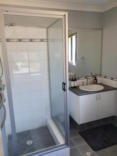 La salle de bains est pourvue d'une douche et d'un lavabo. dans l'établissement Dalyellup Private Guest House unit, à Bunbury