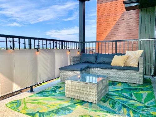 een patio met een bank en een tafel op een balkon bij Peaceful Oasis Condo, AC, Top Floor, Secure UG Parking, Balcony, King Bed! in Edmonton