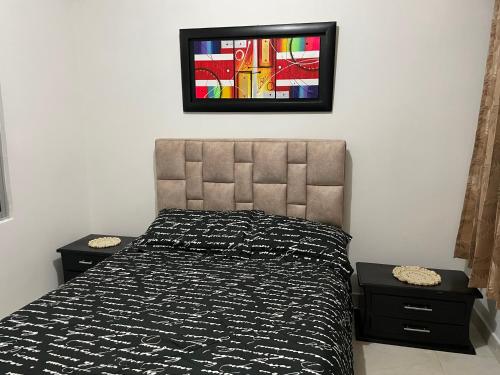 a bedroom with a bed and a tv on the wall at Apartamento cerca a la candelaria y hospitales principales de Bogota in Bogotá