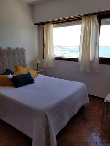 1 dormitorio con 1 cama grande y 2 ventanas en Departamento en Varese frente al mar en Mar del Plata