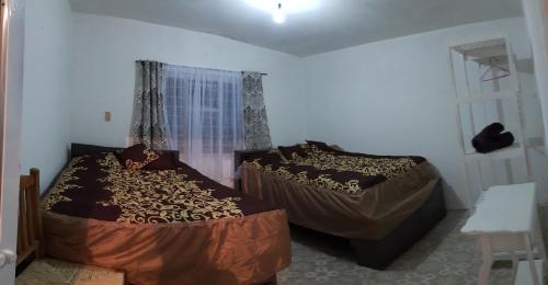 1 dormitorio con 2 camas y ventana en Casa Don Rubén, en Malinalco