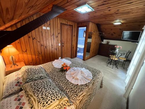 a bedroom with a leopard print bed with umbrellas on it at Pousada Heron in Campos do Jordão
