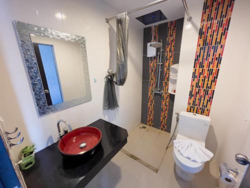 a bathroom with a red sink and a toilet at Melissa Kata Beach Resort in Kata Beach