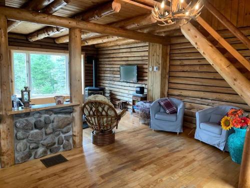 a living room with two chairs and a tv in a cabin at Cozy log cottage in La Minerve