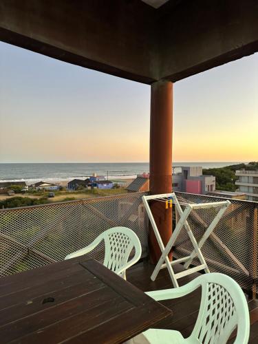 dwa krzesła i stół na balkonie z widokiem na ocean w obiekcie Apart Costa Esmeralda w mieście Ostende