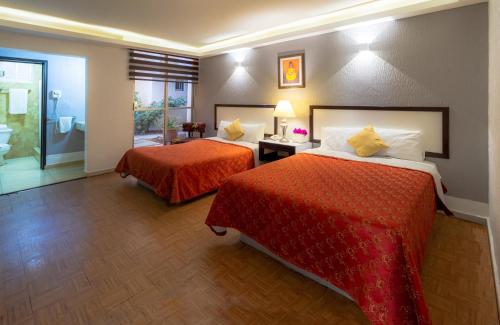 ein Hotelzimmer mit 2 Betten und einem Bad in der Unterkunft Hotel del Valle Inn in Pachuca de Soto