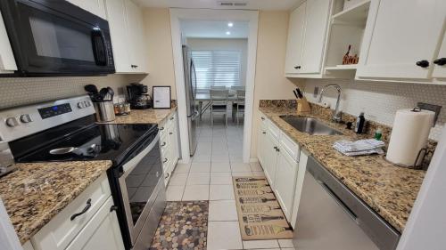 La cuisine est équipée de placards blancs, d'un évier et d'un four micro-ondes. dans l'établissement HHI Homes LLC, à Île de Hilton-Head
