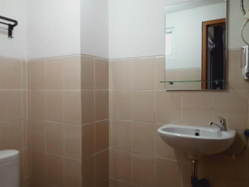 a bathroom with a sink and a mirror at De Green Inn Serua in Dukuh